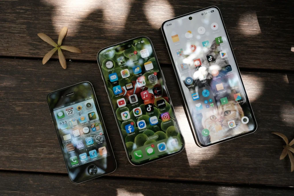 Smartphone displaying before and after photo comparison of enhanced vintage photo, person