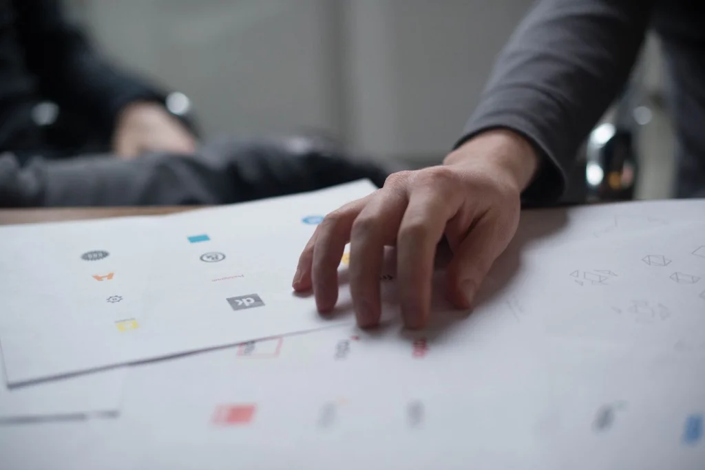 Close-up hands of graphic designer in his 20s, adjusting opacity and blend settings on computer screen, showing PNG transparency options in software interface, warm desk lamp lighting, macro shot of fingers on mouse and keyboard, professional workflow photography