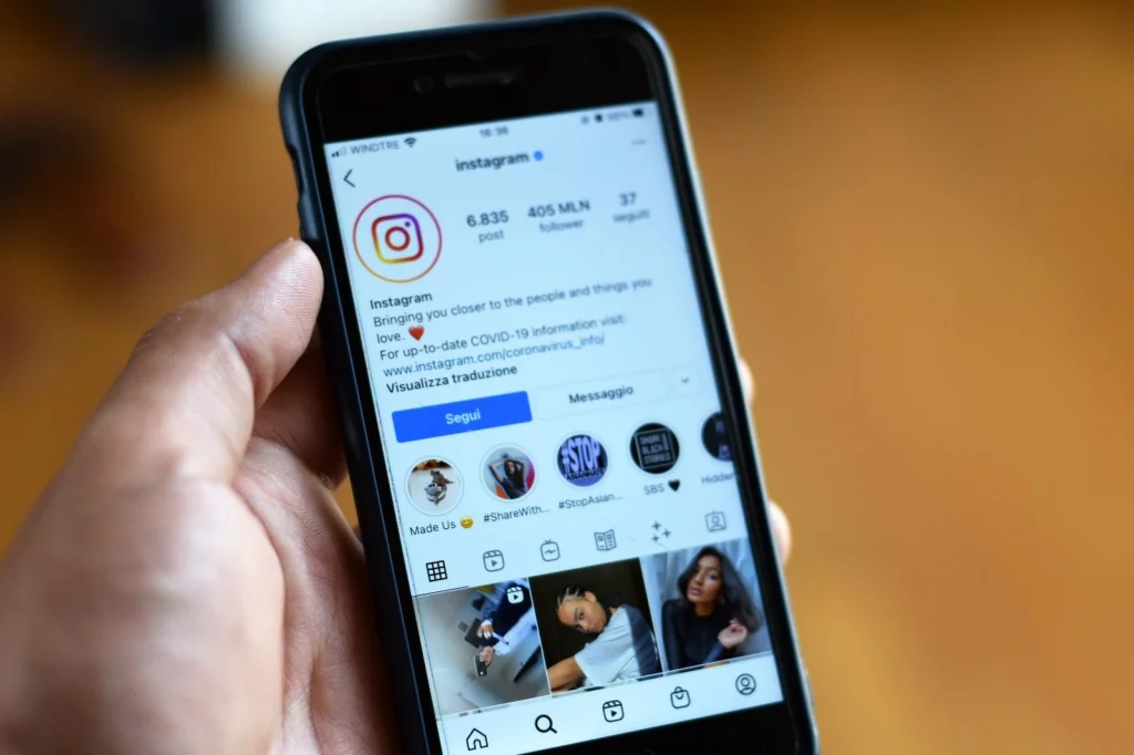 Smartphone displaying Instagram story with beauty influencer photo, colorful gradient background, ring light reflection on screen, modern minimalist desk setup, natural window light from side, overhead flat-lay, social media lifestyle photography